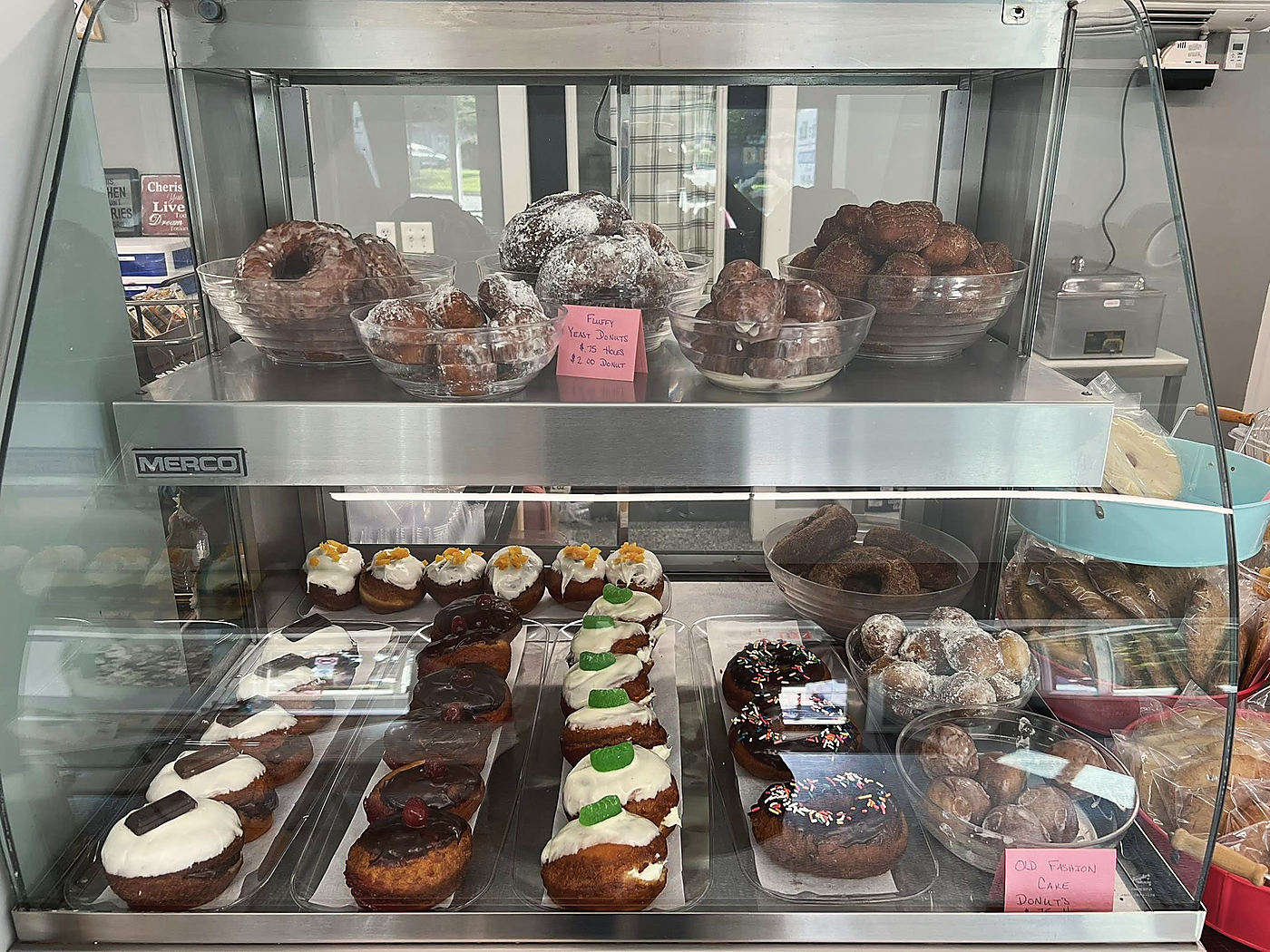 The bakery case: donuts and iced pastries on two shelves