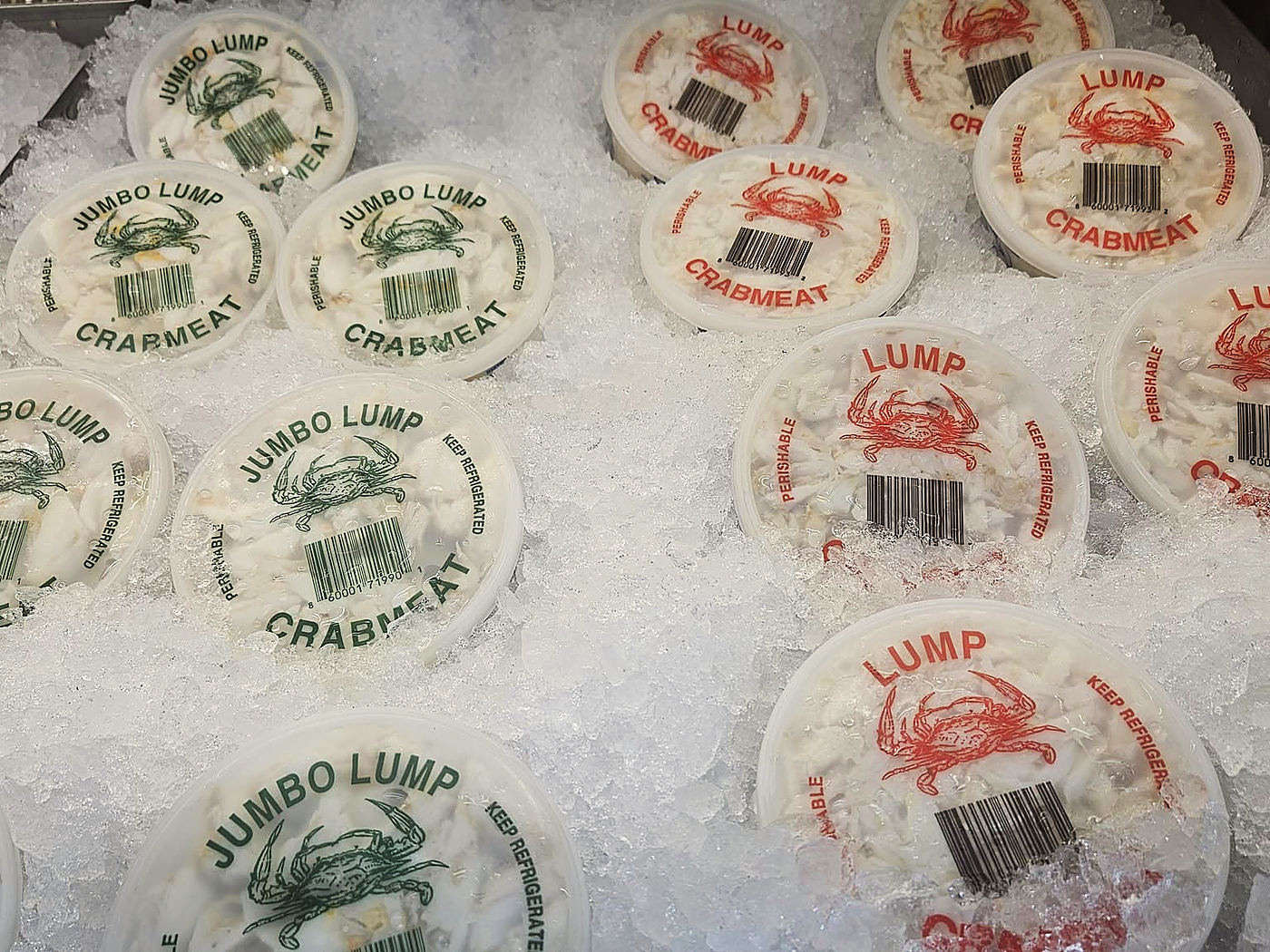 Tubs marked Jumbo Lump Crabmeat and Lump Crabmeat on crushed ice