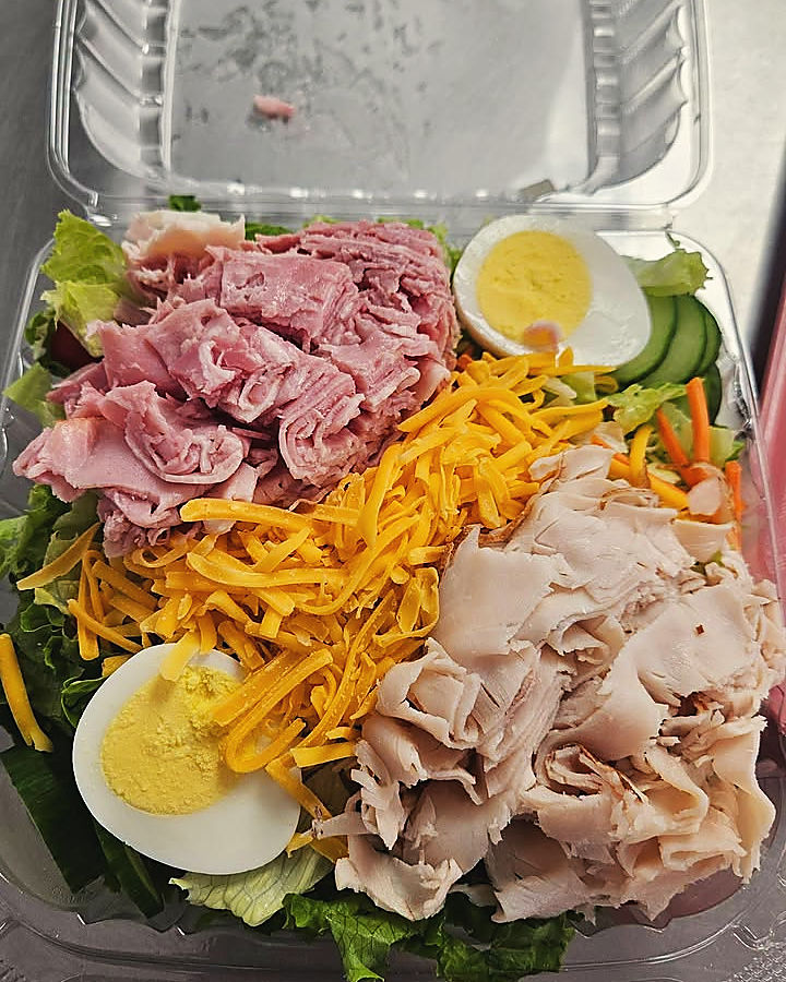 A chef salad, boxed to go